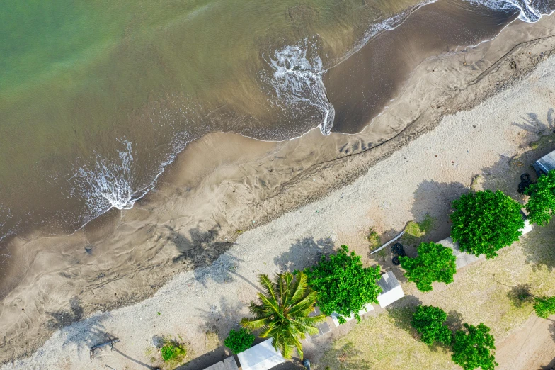 an aerial view of a beach next to a body of water, pexels contest winner, visual art, campsites, thumbnail, jamaica, grey