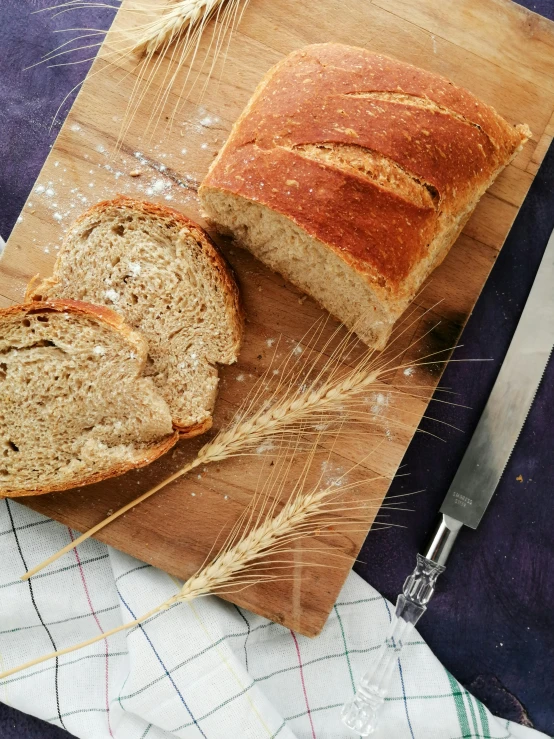 a loaf of bread sitting on top of a cutting board, award - winning crisp details ”, light scatter, large tall, cozy