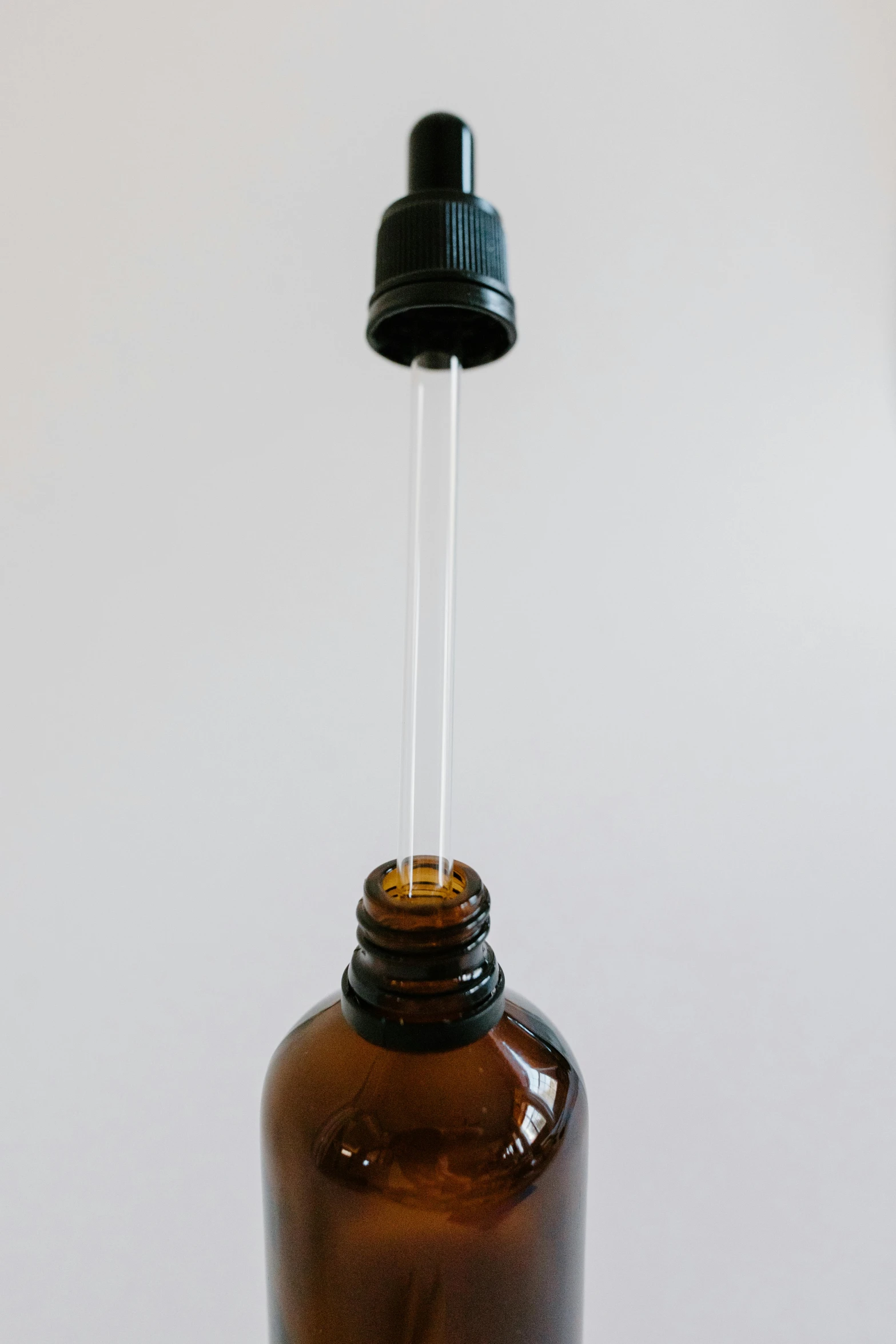 a brown glass bottle with a black cap, by Gavin Hamilton, unsplash, process art, iv pole, light sensor, detail, assembly instructions