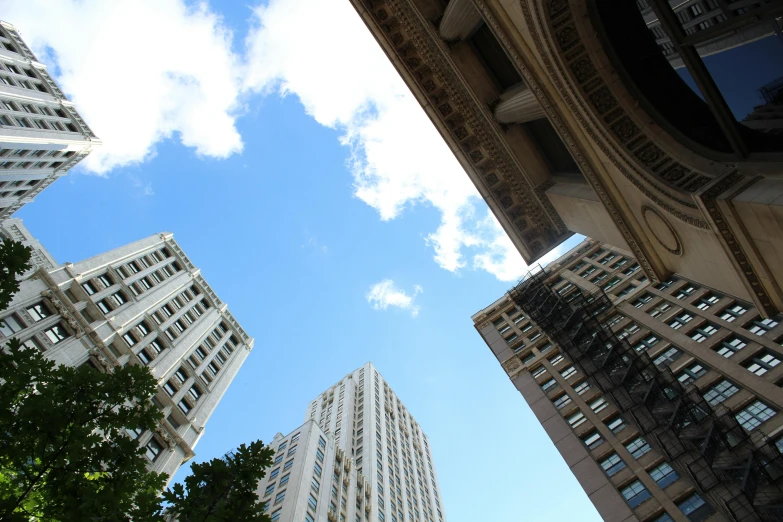 a group of tall buildings sitting next to each other, a photo, inspired by Sydney Prior Hall, unsplash, clear blue skies, on a great neoclassical square, view from bottom, white pale concrete city