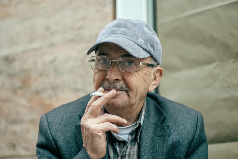 a man with glasses and a hat smoking a cigarette, by William Berra, pexels contest winner, fluxus, photo of džesika devic, very slightly smiling, oldman with mustach, 2 5 6 x 2 5 6 pixels