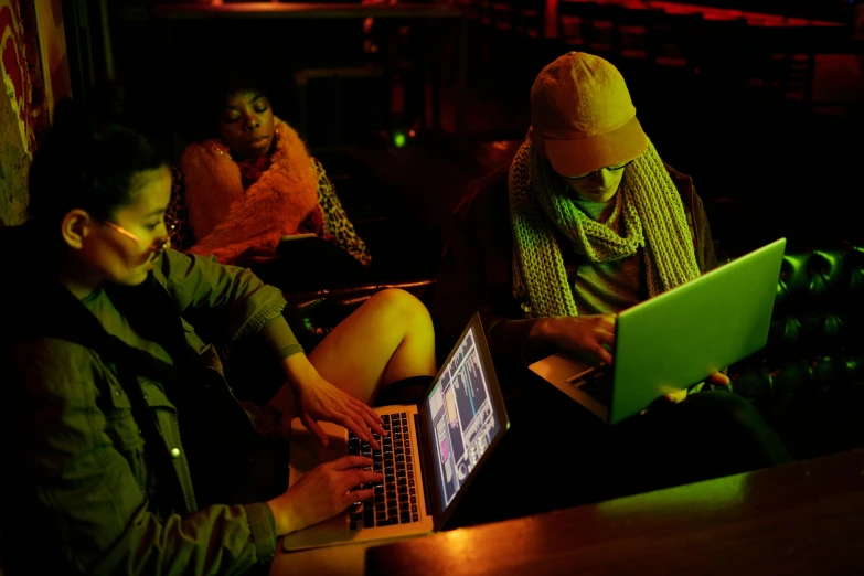 a group of people sitting around a table with laptops, pexels, computer art, night clubs and neons, performance, hunting, afro tech