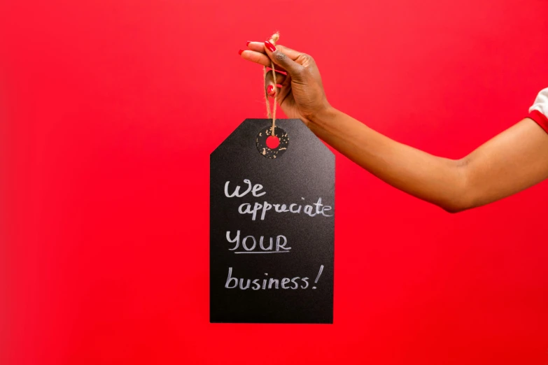 a woman holding a sign that says we approach your business, pexels contest winner, private press, red and black colour scheme, product photography, closeup - view, instagram post