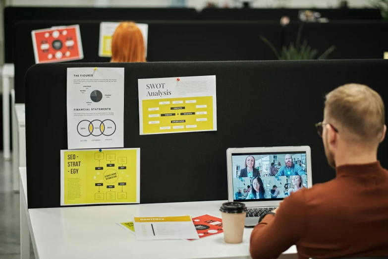 a man sitting at a desk with a laptop, by Julia Pishtar, serial art, black and yellow and red scheme, in an call centre office, indi creates, storyboard