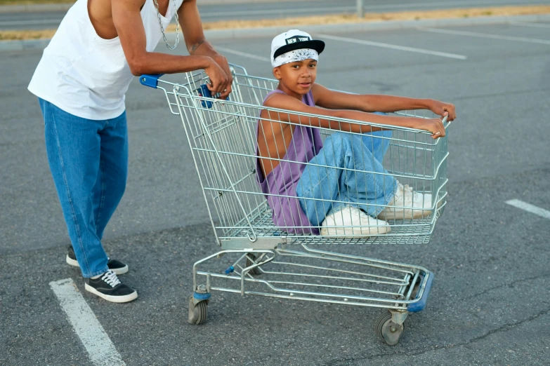 a woman pushing a boy in a shopping cart, by Everett Warner, unsplash, renaissance, lowriders, square, wearing a baggy, ignant