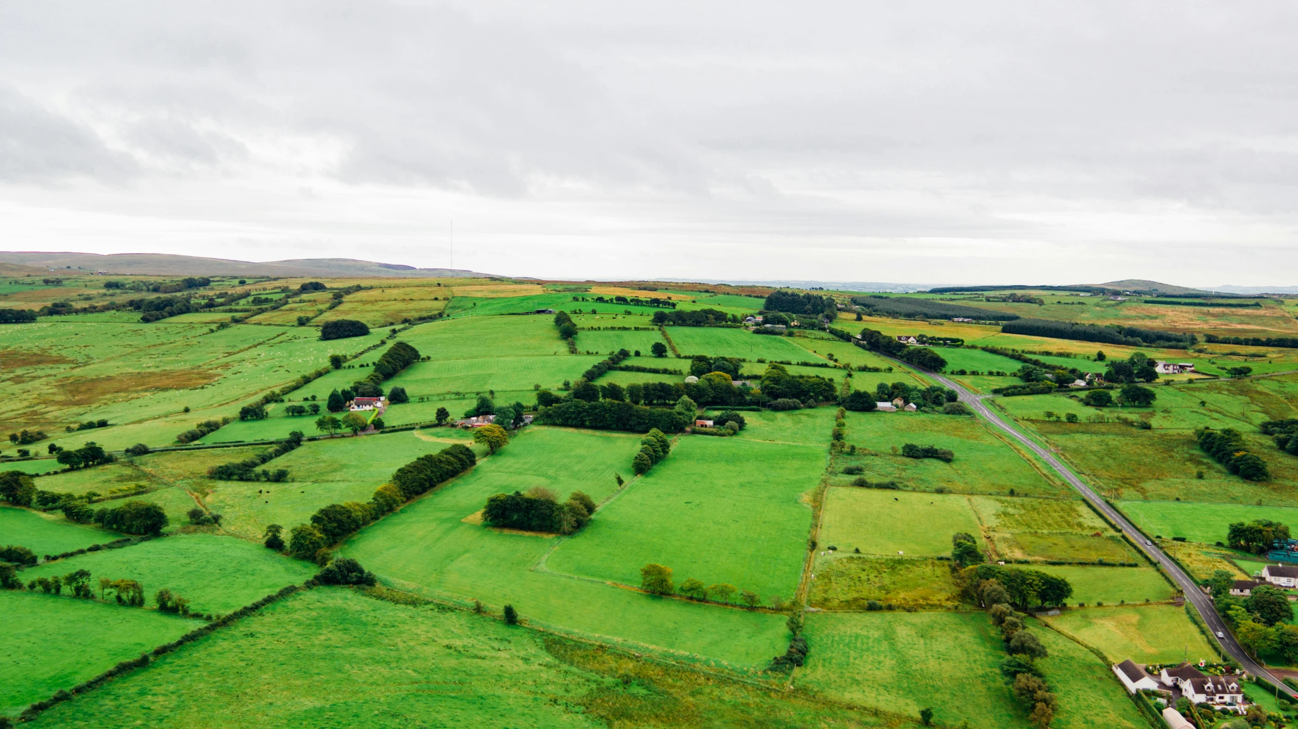 an aerial view of a lush green field, by Julian Hatton, pexels contest winner, hurufiyya, marsden, panoramic view, next to farm fields and trees, overlooking