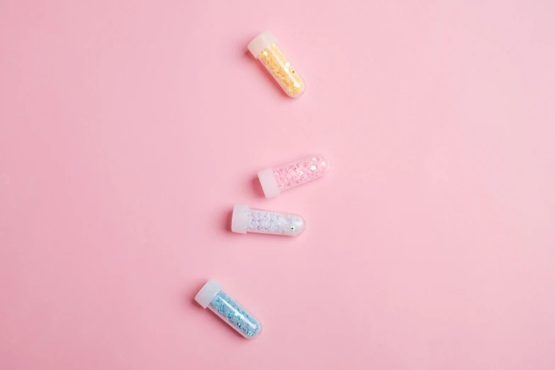 pills on a pink background, inspired by Pearl Frush, glitter gif, pathology sample test tubes, 4 colors, product photo