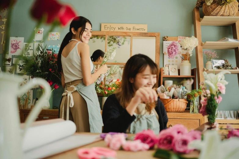 two women sitting at a table in a flower shop, pexels contest winner, joy ang, all overly excited, people at work, small manufacture