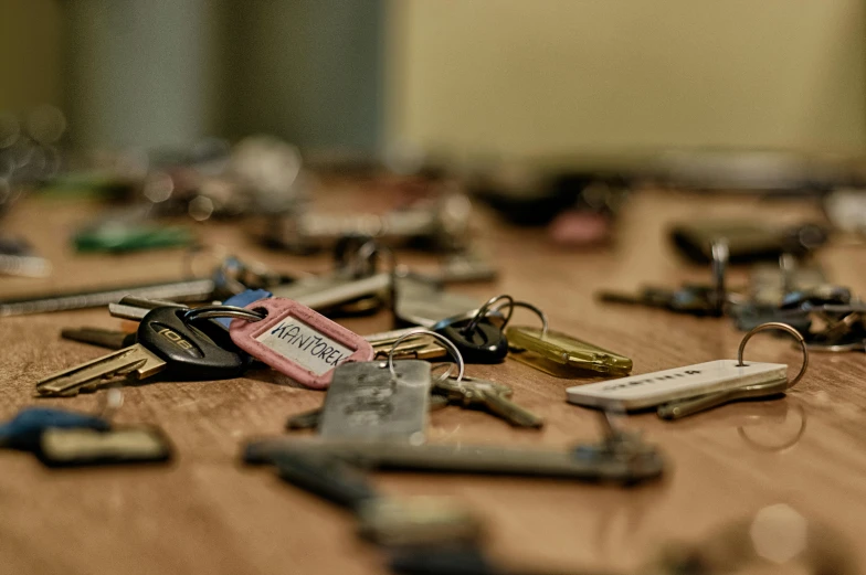 a bunch of keys sitting on top of a wooden table, unsplash, hyperrealism, museum photo, multiple stories, 1 9 7 0 s photo, open plan