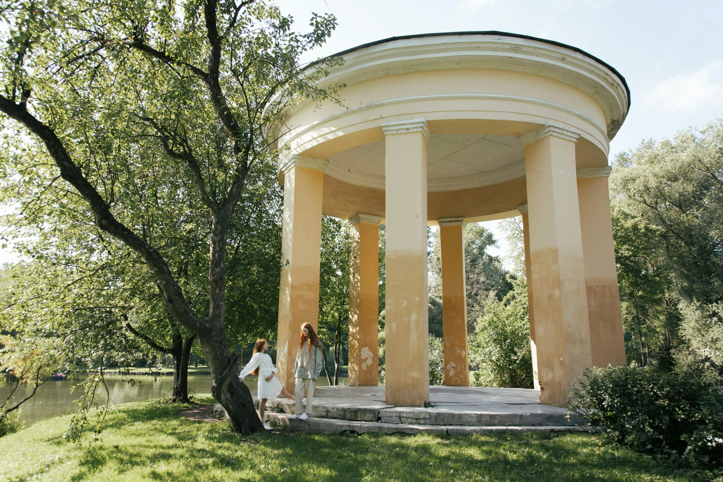 a man and a woman standing in front of a gazebo, by Emma Andijewska, unsplash, neoclassicism, terracotta, panorama, levitan, soft shade