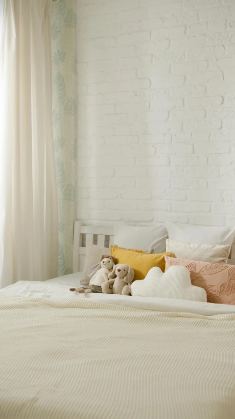 a white bed sitting in a bedroom next to a window, a cartoon, shutterstock, minimalism, toys, modern studio light soft colour, cushions, brick