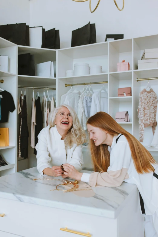 a couple of women standing next to each other in a closet, trending on pexels, renaissance, earing a shirt laughing, sitting on a store shelf, white marble interior photograph, gif