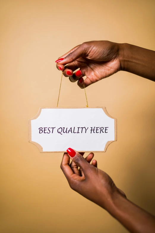 a woman holding a sign that says best quality here, by Julia Pishtar, trending on unsplash, harlem renaissance, crafts, high quality photo, made of glazed, hq print