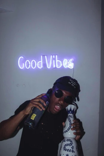 a man talking on a cell phone while holding a bottle, an album cover, by Robbie Trevino, trending on pexels, glow sticks, really good vibes, black teenage boy, thumbs up