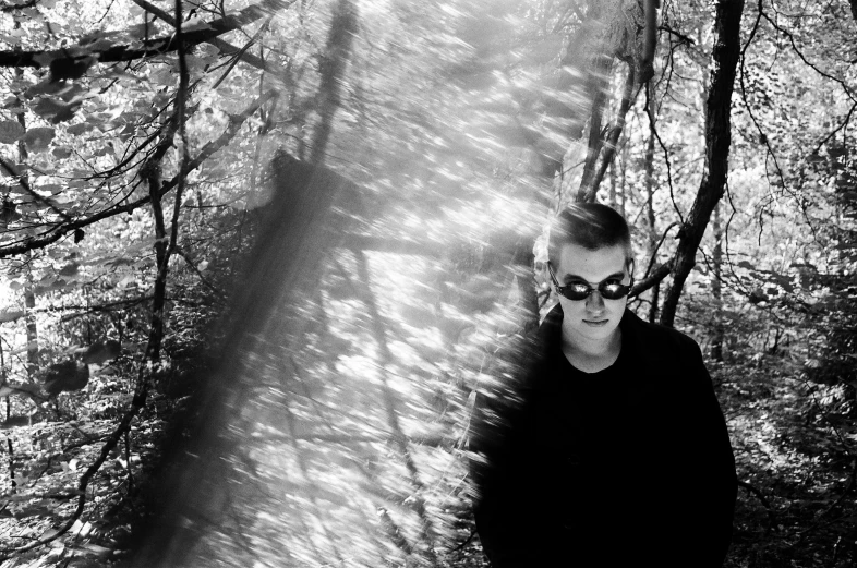 a black and white photo of a man in the woods, purism, with sunglass, volumeric ghostly rays, photo from a promo shoot, currents