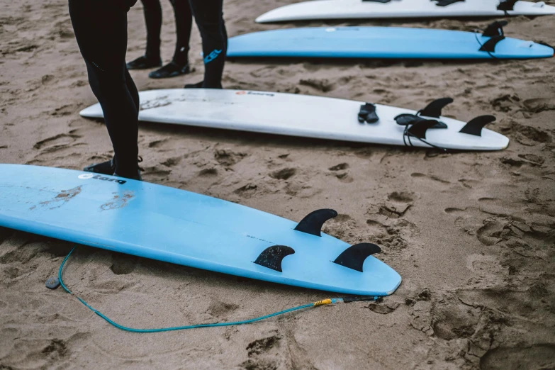 a group of people standing on top of a beach next to surfboards, up-close, thick blue lines, laying down, on a canva