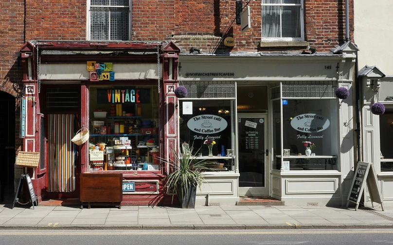 a book store sitting on the side of a street, unsplash, arts and crafts movement, viridian and venetian red, shop front, sam shearon, andrew dickson