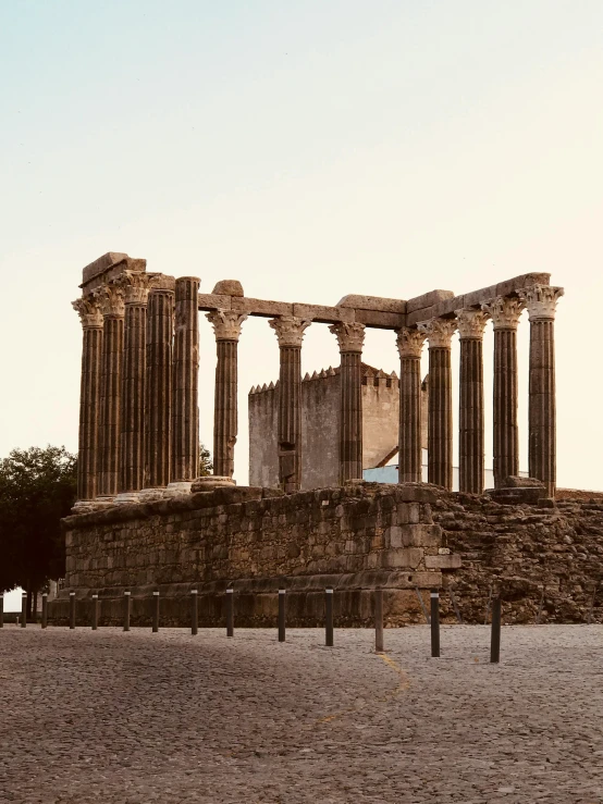 a large stone structure sitting on top of a sandy field, pexels contest winner, neoclassicism, surrounding the city, greek temple, promo image, portugal