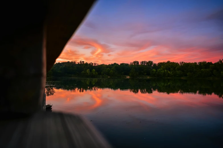 a sunset over a body of water with trees in the background, by Neil Blevins, pexels contest winner, bridge over the water, details and vivid colors, low wide angle shot, instagram photo