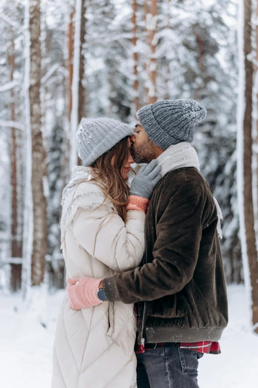 a man and woman standing next to each other in the snow, pexels contest winner, romanticism, kissing together cutely, 🚿🗝📝, wearing wool hat, hunting