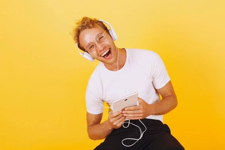 a man that is sitting down with headphones on, trending on pexels, happening, laughing maniacally, avatar image, blonde guy, yellow hue