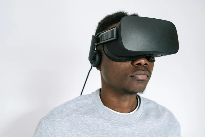 a man wearing a virtual reality headset, by Carey Morris, trending on unsplash, afrofuturism, on grey background, educational, plain background, wearing a gaming headset