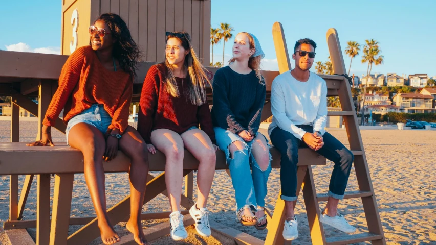 a group of people sitting on top of a wooden bench, trending on unsplash, teenage girl, santa monica beach, profile image, polychromatic