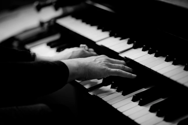 a close up of a person playing a piano, a black and white photo, by Matija Jama, pexels, 15081959 21121991 01012000 4k, closed hands, digitally remastered, andrzej marszalek