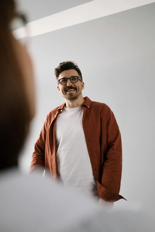 a man standing in front of a mirror talking on a cell phone, pexels contest winner, photorealism, rhett and link, basic white background, smiling man, ute osterwalder