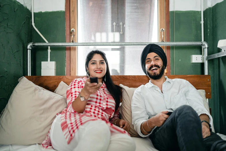 a man and a woman sitting on a bed, inspired by Manjit Bawa, pexels, happening, watching tv, both smiling for the camera, avatar image, plan