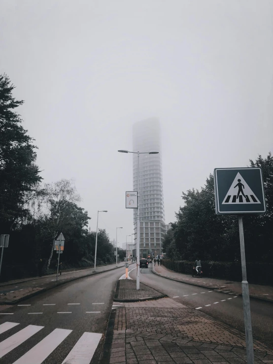 a street sign sitting on the side of a road, by Adam Willaerts, pexels contest winner, tall towers, in low fog, julia hetta, college