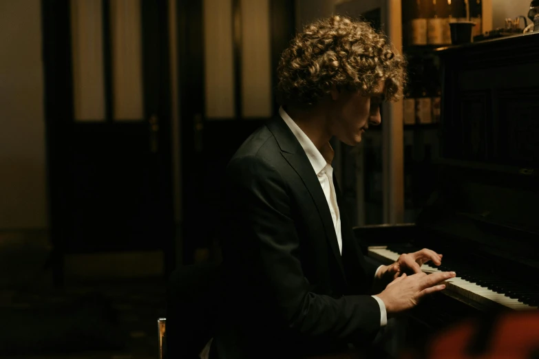a man in a suit playing a piano, an album cover, by Daniel Seghers, pexels contest winner, blond curly hair, ignant, romance, 4 k cinematic still