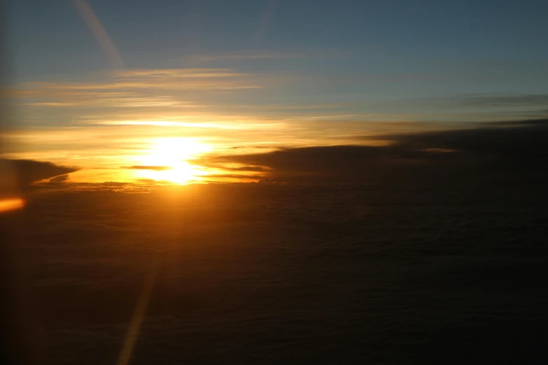 a sunset seen through the window of an airplane, by Ian Fairweather, hurufiyya, low quality photo, full daylight