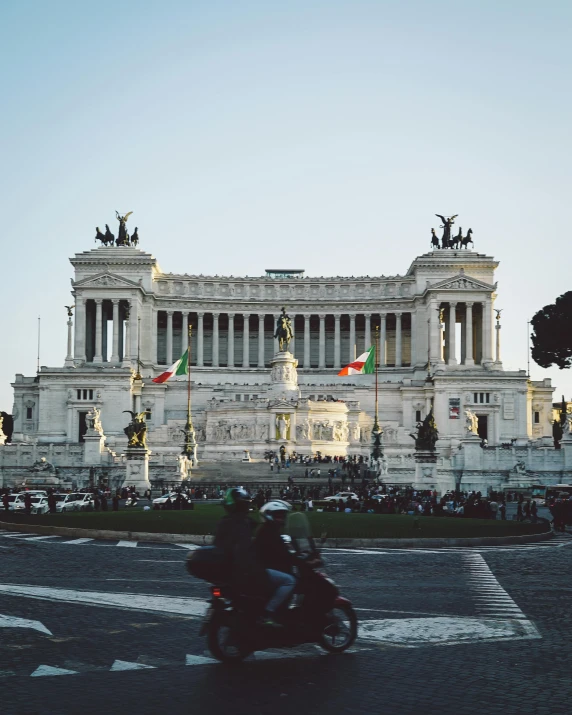 a person riding a motorcycle in front of a building, a marble sculpture, pexels contest winner, neoclassicism, italian flag, lesbians, palace on top of the hill, inauguration