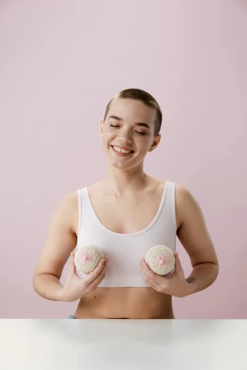a woman in a white tank top holding two donuts, by Arabella Rankin, wearing bionic implants, posing together in bra, nonbinary model, covered in pink flesh