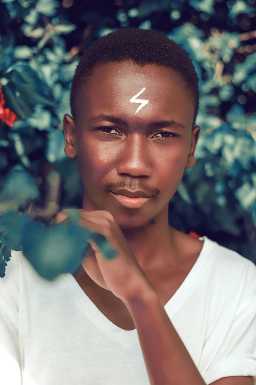 a man in a white shirt posing for a picture, an album cover, inspired by David Bailly, trending on pexels, afrofuturism, lightning bolt scar on forehead, black teenage boy, lush surroundings, ( brown skin )