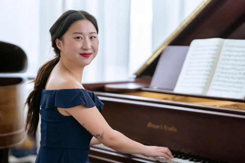 a woman in a blue dress playing a piano, louise zhang, portrait image, slightly smiling, student