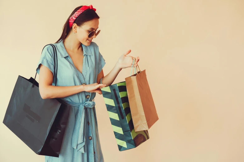a woman in a blue dress holding shopping bags, trending on pexels, green and brown clothes, woman with rose tinted glasses, retro colour, asian woman made from origami