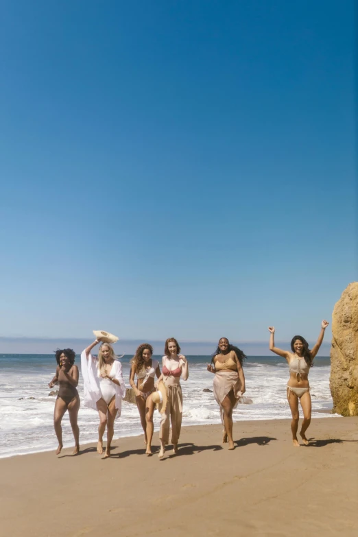 a group of women standing on top of a sandy beach, lizzo, coming out of the ocean, production photo, malibu canyon