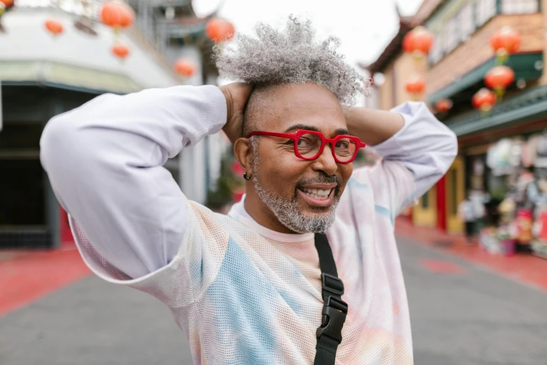 a man with glasses standing in the middle of a street, trending on pexels, happening, cheerful colours, samurai with afro, grey hair, color red