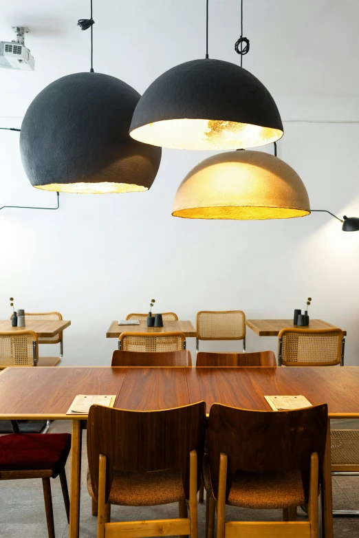 a dining room filled with wooden tables and chairs, inspired by Barthélemy Menn, unsplash, light and space, retro lights, clamp shell lighting, low detail, colombian