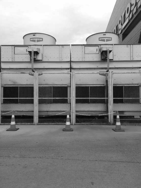 a black and white photo of a parking lot, inspired by Robert Bechtle, unsplash, brutalism, air conditioner, two towers, industrial colours, ilustration