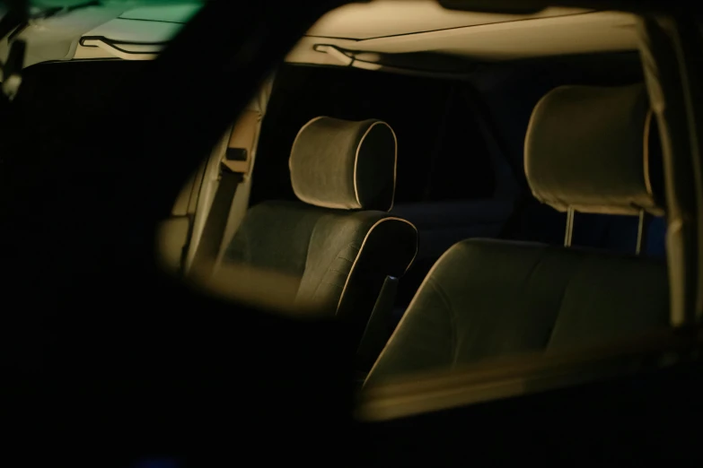 a rear view mirror of a car in the dark, an album cover, inspired by Elsa Bleda, unsplash, purism, sitting down, luminous cockpit, nighttime, leather interior