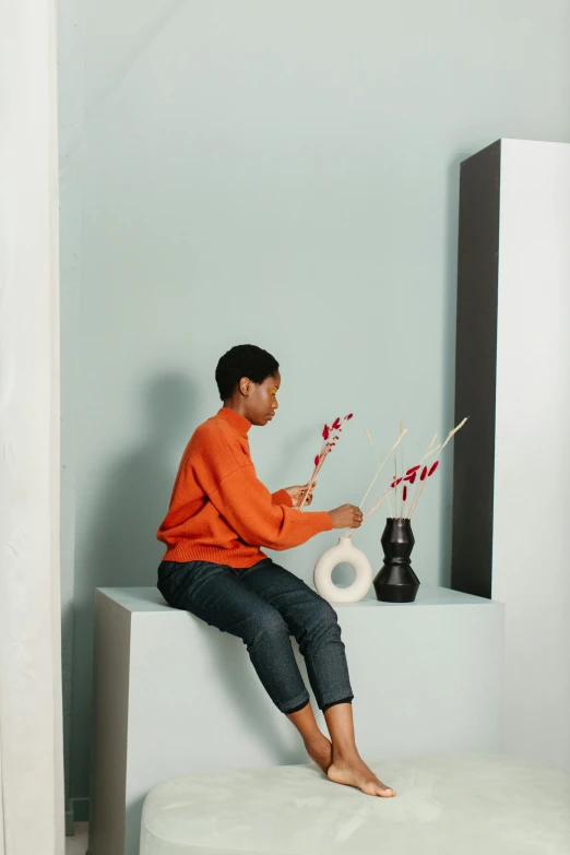 a person sitting on a bench in a room, ikebana, on a candle holder, maria borges, ashteroth