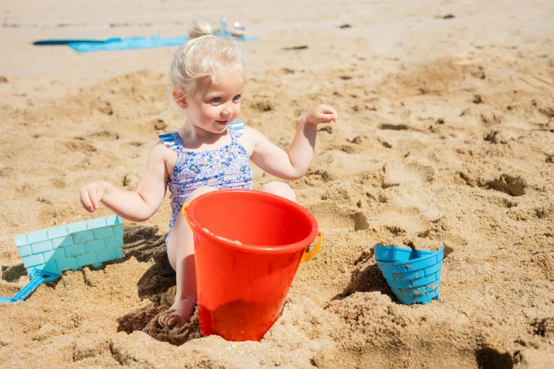 a little girl sitting on top of a sandy beach, multicoloured, cone shaped, alexa grace, thumbnail