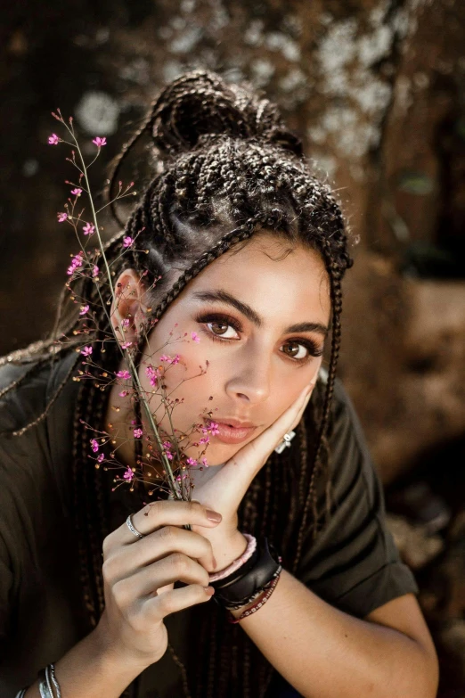 a woman with dreadlocks posing for a picture, an album cover, by irakli nadar, trending on pexels, young middle eastern woman, flowers, cornrows, dreamy mila kunis