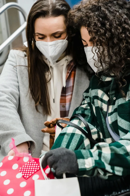 a couple of women standing next to each other, trending on pexels, happening, medical mask, giving gifts to people, square, highly detailded