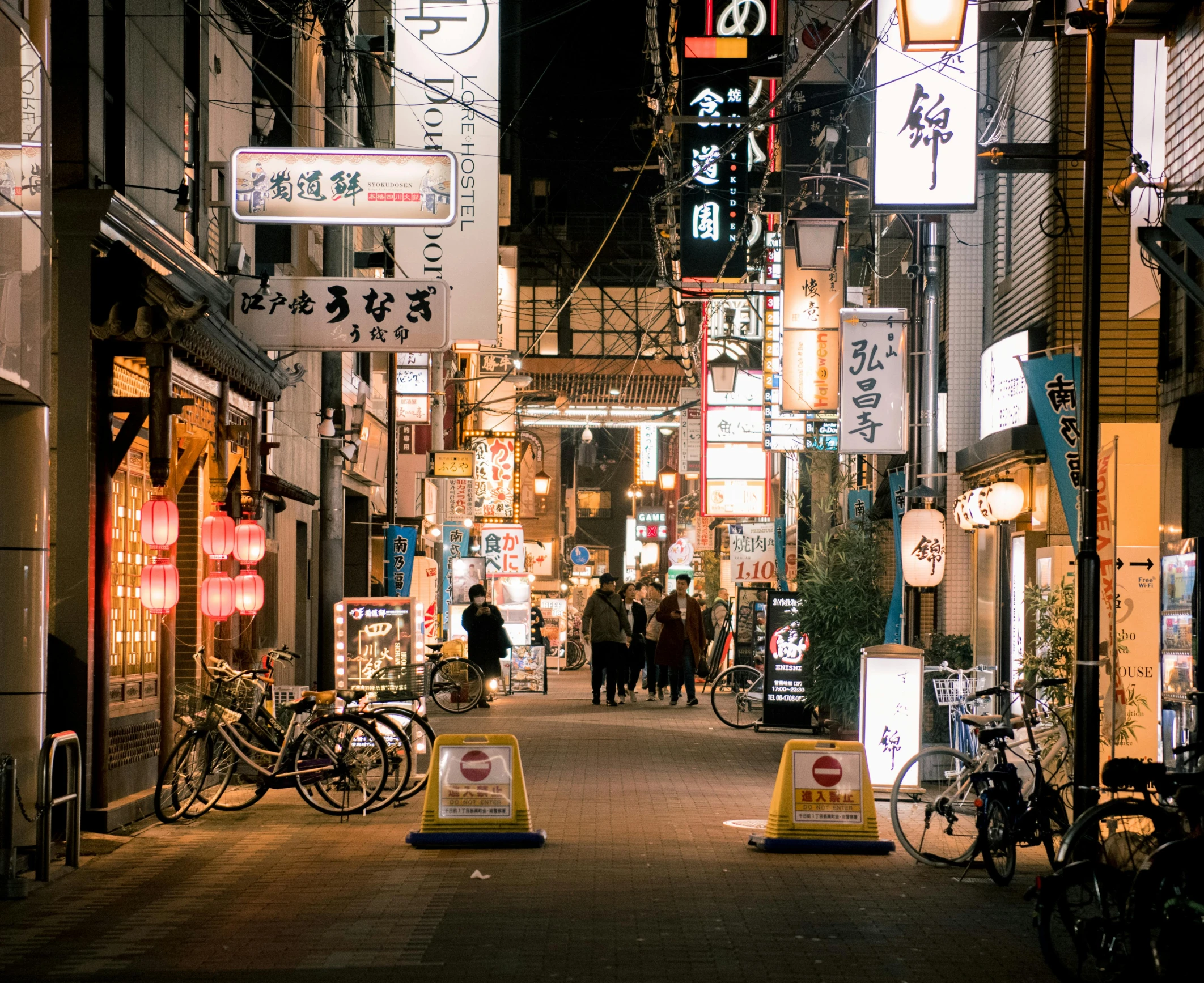 a group of people walking down a street at night, a photo, trending on unsplash, ukiyo-e, lots of signs and shops, empty streetscapes, local illumination, historical photo