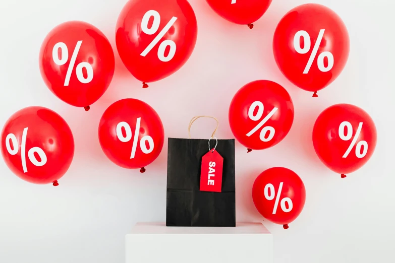 a black shopping bag sitting on top of a pile of red balloons, maths, curated collections, profile image, medium close shot