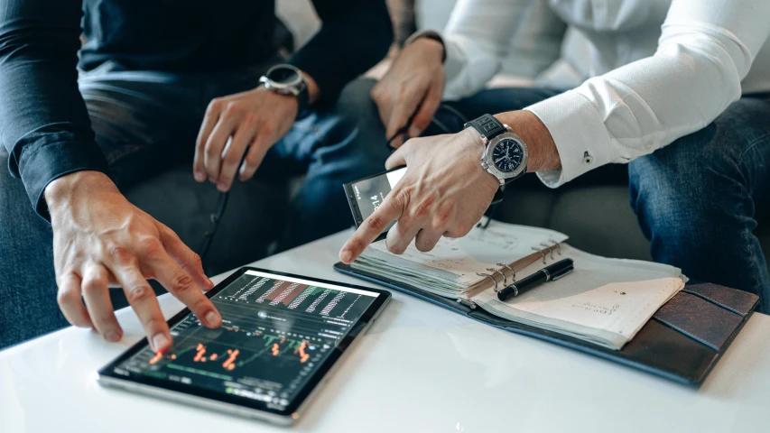 a couple of men sitting next to each other on a couch, trending on pexels, analytical art, displaying stock charts, hands on counter, thumbnail, inspect in inventory image